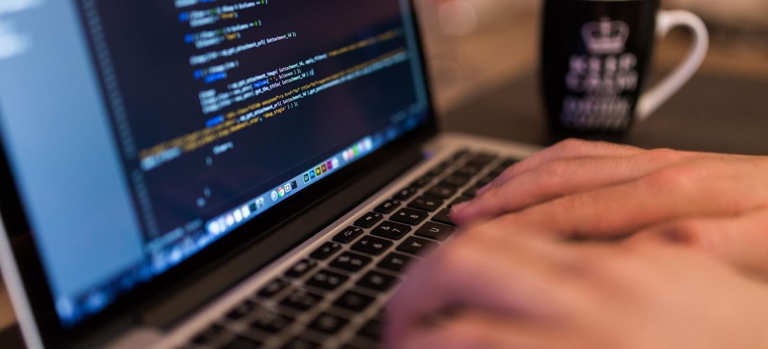 A person coding on a laptop